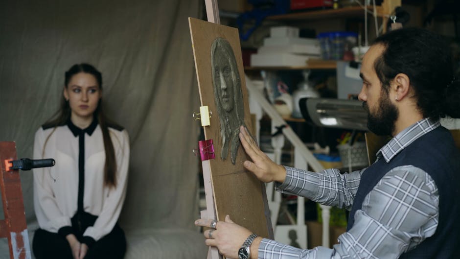 A male artist sculpts a female portrait on canvas in a studio setup.